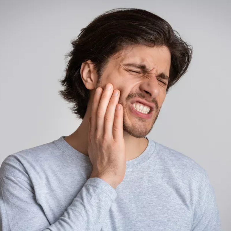 Homme souffrant d’un mal de dents, se tenant la joue avec douleur – image illustrant les causes et solutions contre la douleur dentaire avec DentalPro Smile.